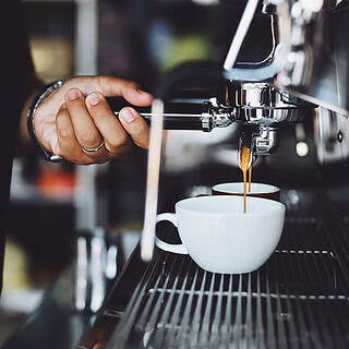 man sieht eine Siebträgermaschine, die zwei Tassen mit Kaffee befüllt- Sensorikkurs Mini in Dresden