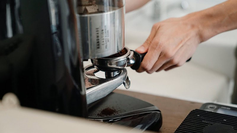Ansicht einer elektrischen Kaffeemühle, die einen Siebträger mit Kaffeepulver füllt- Sensorikkurs Mini in Dresden