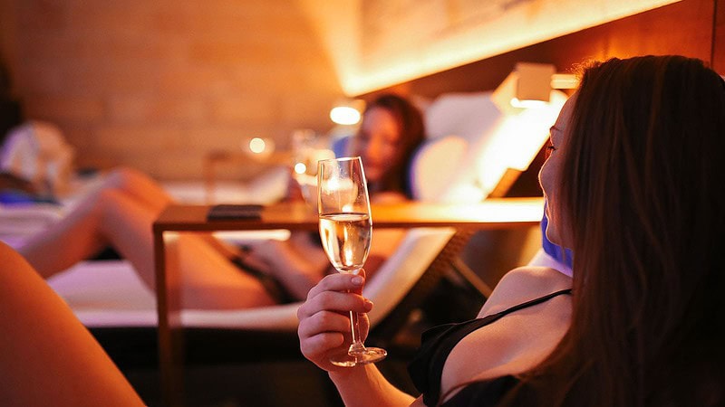 Frau trinkt Glas Sekt im Spa vor der Hot Stone Massage in Dresden