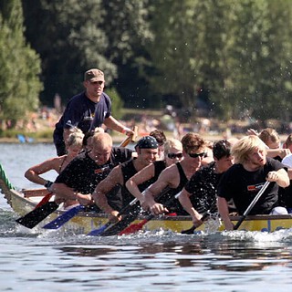 Gruppe von Menschen paddeln kräftig in einem Drachenboot