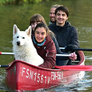 Familie mit Hund beim Kanufahren