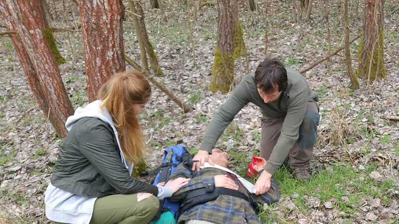 Frau und Mann beim verarzten eines Mannes.