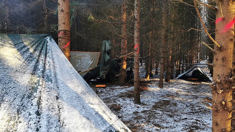 Verschneites Tarp mit Blick in den Wald