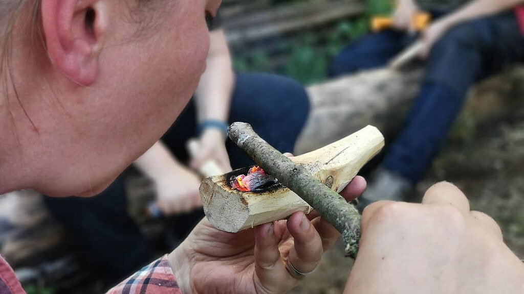 Survival Wochenende für Frauen Frau entfacht Feuer mit kleinem Holz Frau entfacht Feuer mit klienem Holz.