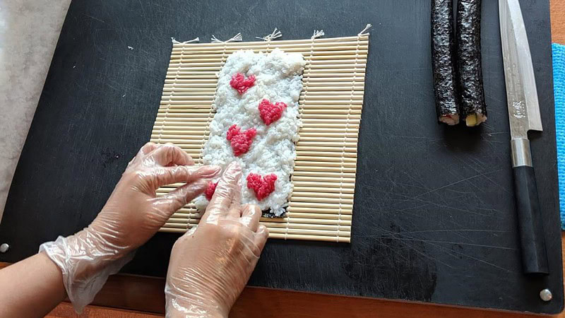 Reis wird auf der Matte ausgebreitet - Sushi Kochkurs