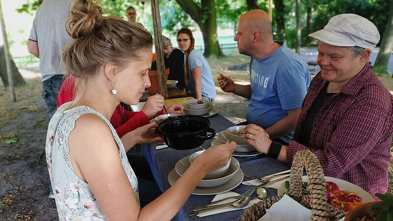 Frauen und Männer am Campingtisch beim Essen.