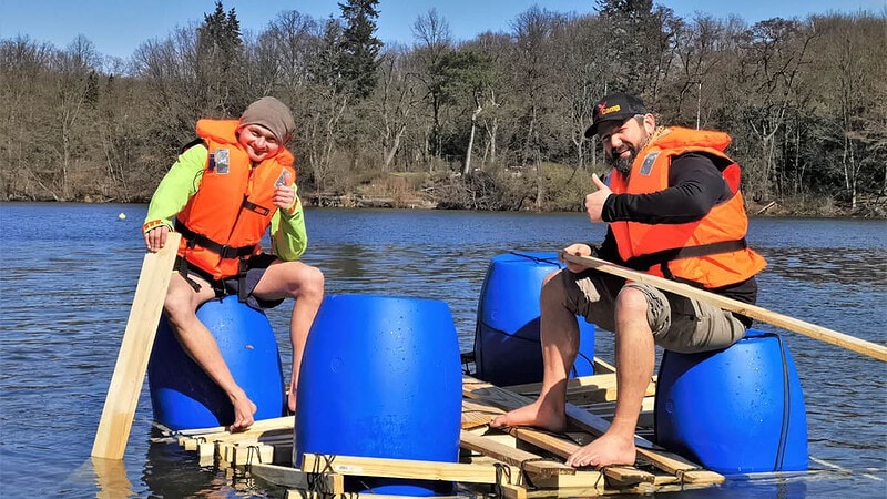 Zwei Männer sitzend auf dem Floß