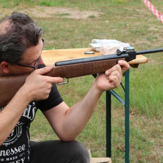 Mann beim Zielen mit Luftgewehr.