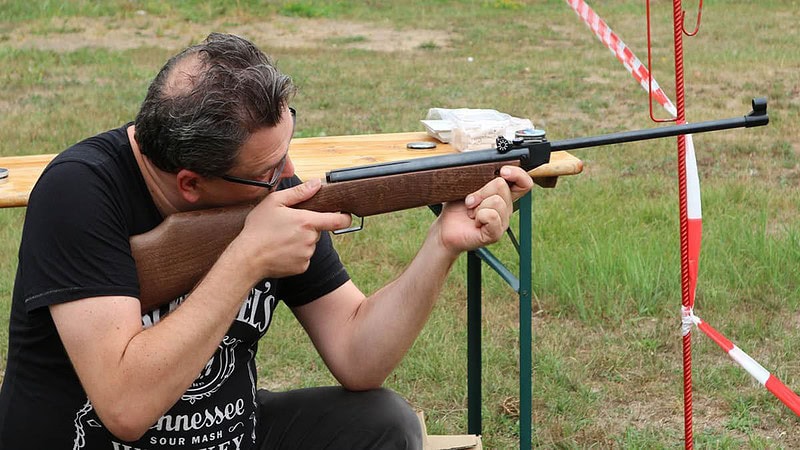 Mann beim Zielen mit Luftgewehr.