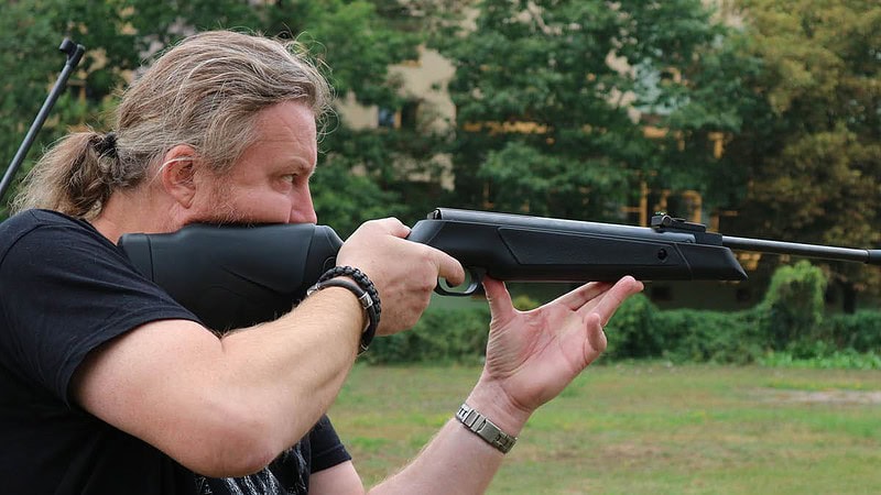 Mann mit Luftgewehr beim Zielen.
