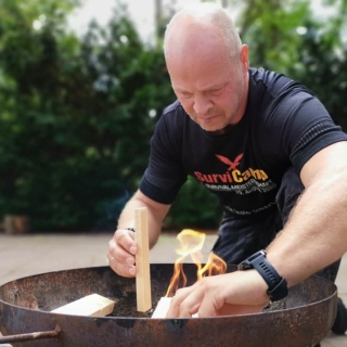 Mann beim Feuermachen in Feuerschale.