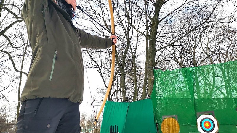 Mann beim Bogenschießen.