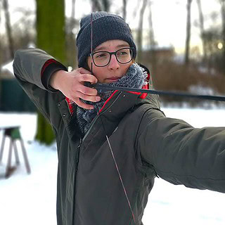 Frau beim Bogen spannen und Zielen.