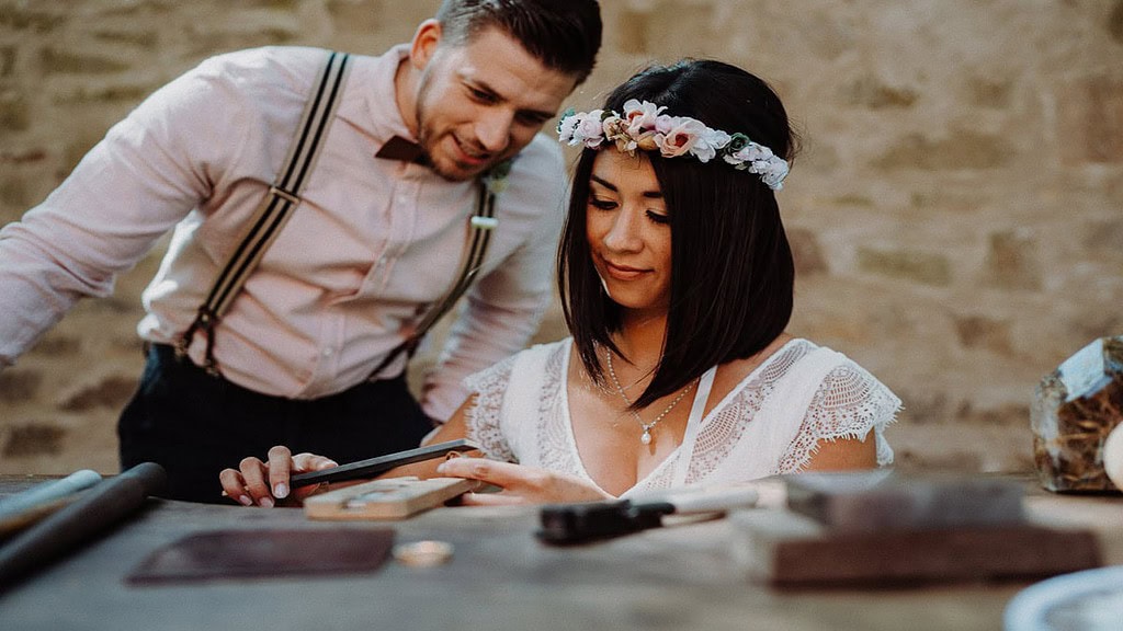 Trauringe-selber-schmieden.jpg Ein Mann und eine Frau schmieden ihren Trauring.