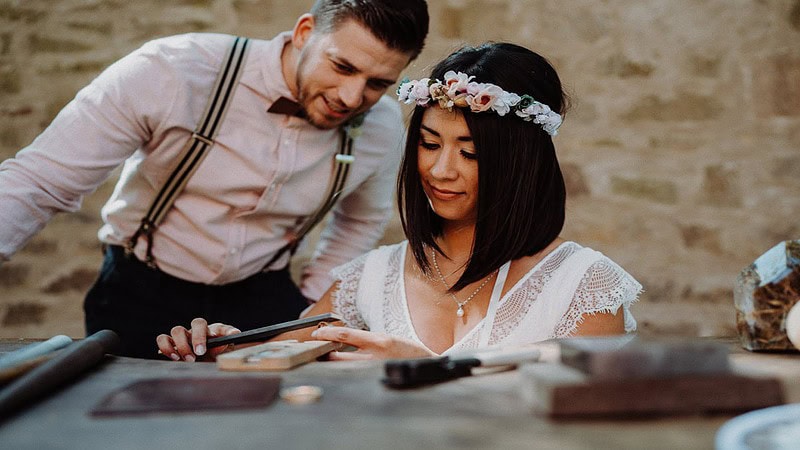 Ein Mann und eine Frau schmieden ihren Trauring.