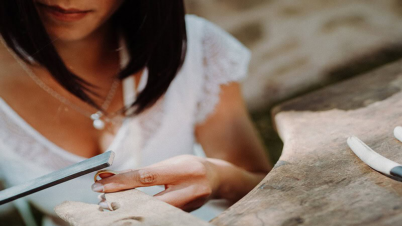 Die Frau in einem Brautkleid schleift ihren selbst gemachten Trauring.