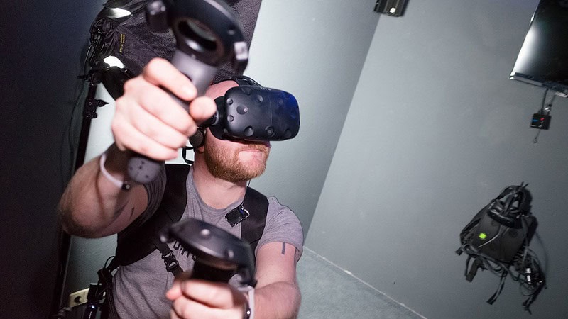 Mann mit VR-Brille und VR-Controllern in der Hand bei Virtual Reality in Leipzig