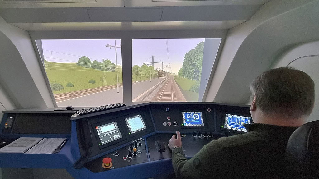 Zugsimulator-Osnabrueck1.jpg Ein Mann bedient den Führerstand der Siemens Vectron Bahn