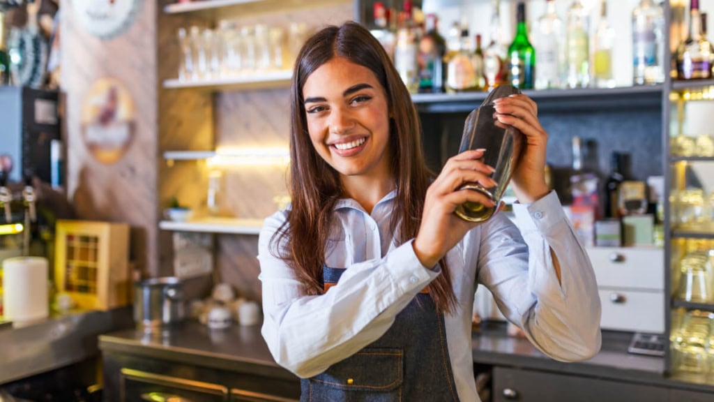 cocktail-kurs (3) Eine lächelnde Bardame mixt Cocktails