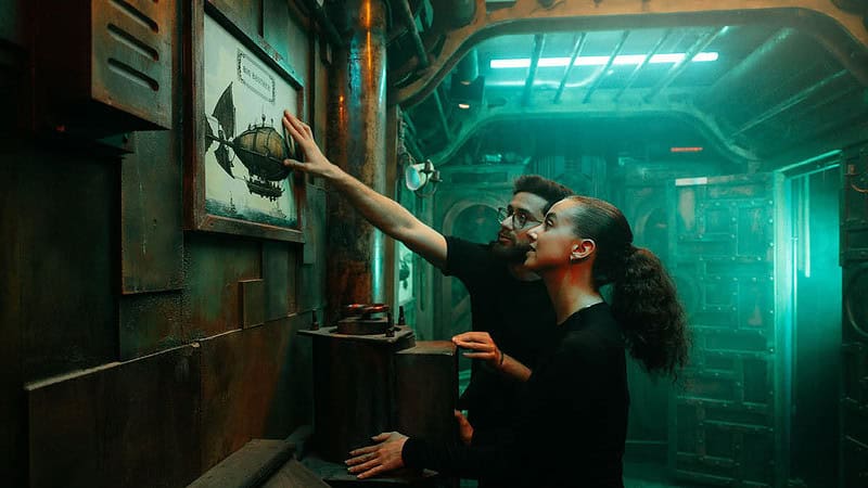 Zwei Personen suchen im Escape Room in Berlin nach einer Lösung - Admiral Kingdom.
