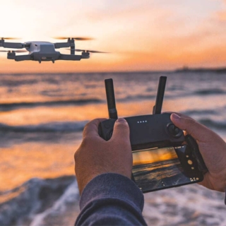 Eine Person nimmt Videos mit einer Drohne am Meer auf