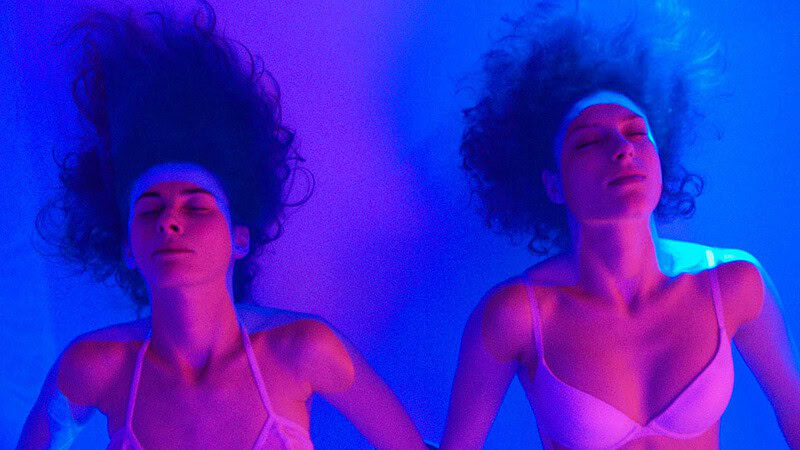 zwei Frauen beim Floating in Berlin Bild von oben mit blauem Licht in Hintergrund