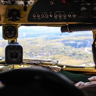Blick auf die Felder aus dem Cockpit eines Kleinflugzeugs