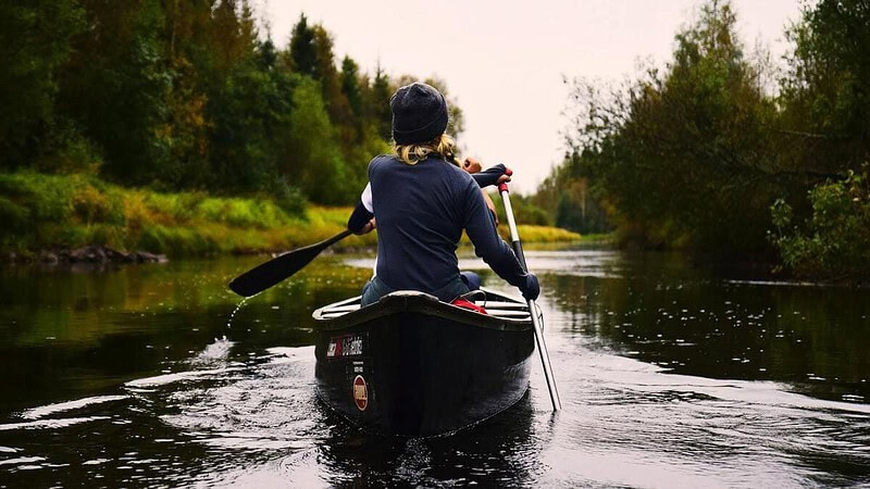 Frau im Canadier in der Natur