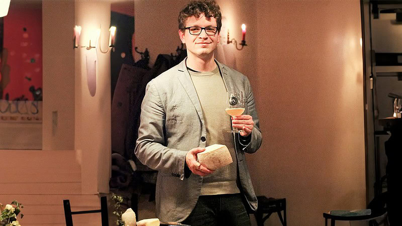 Eine Person steht in der Mitte mit einem Glas Bier und Käse in der Hand beim Bier- und Käseseminar in Leipzig