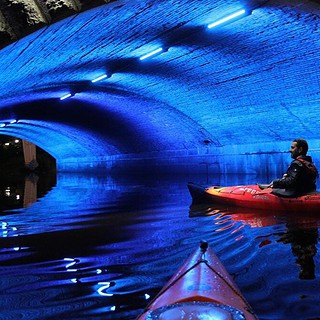Kajak unter Brücke bei Nacht
