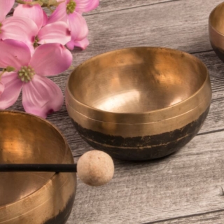 Schalen für Klangschalenmassage zwischen Blumen