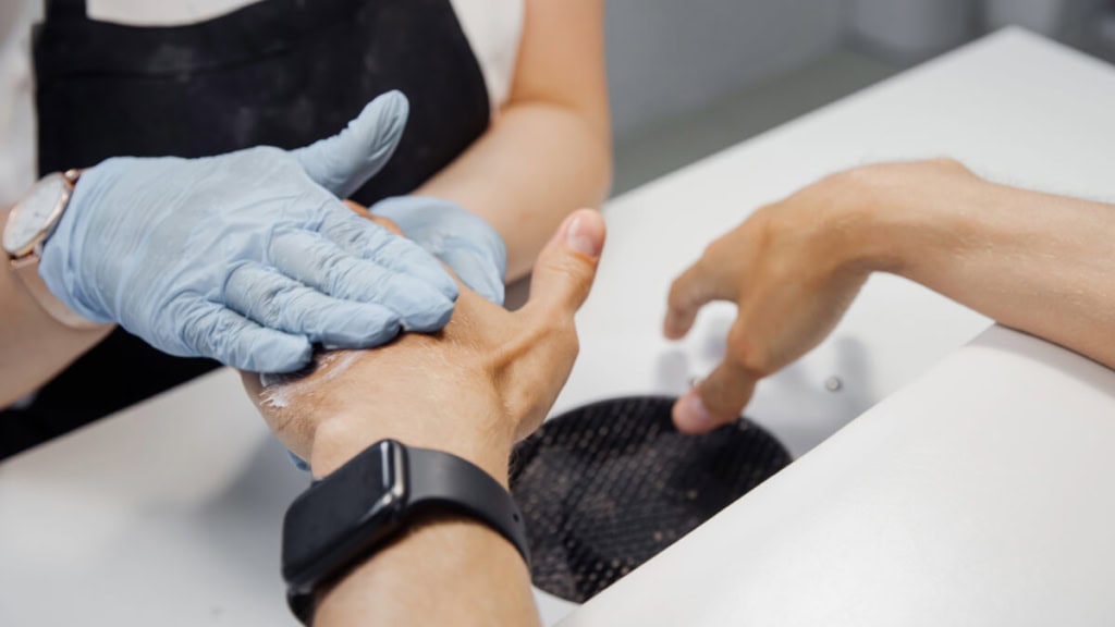 manikuere-maenner Ein Mann genießt eine Maniküre-Behandlung in einem professionellen Schönheitssalon