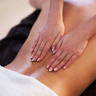 Eine Masseurin wendet Lomi-Lomi-Techniken auf dem Rücken einer Frau an, um sie zu entspannen.