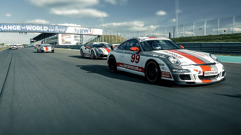 Rennwagen fahren auf der Rennstrecke, vorn der Porsche zu sehen