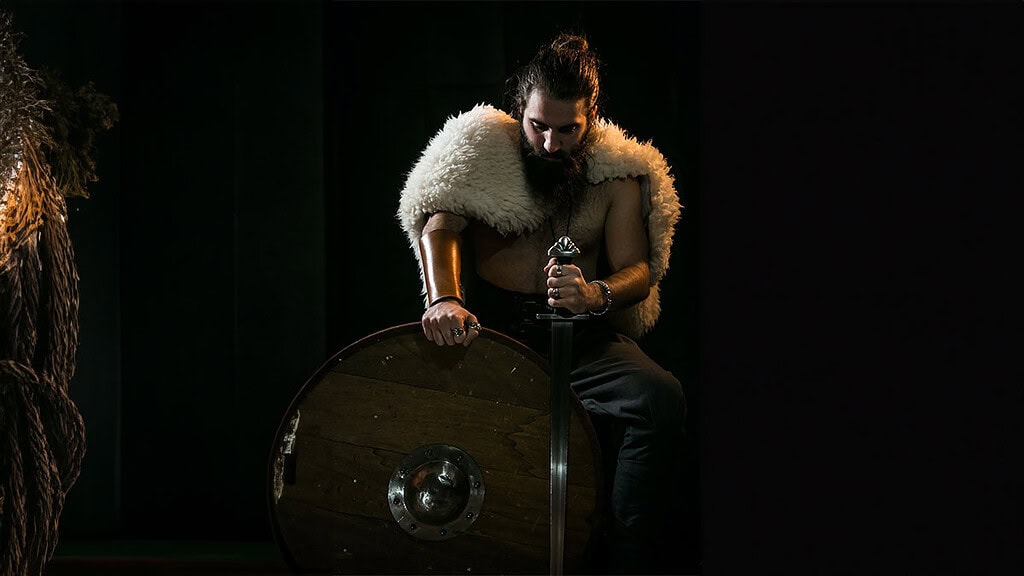 rittermahl-muenchen-komp.jpg Ein Ritter steht im dunklen mit seiner Ausrüstung beim Ritteressen in München