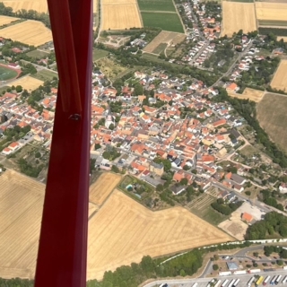 Seitlicher Ausblick auf ein Dorf von einem Flugzeug beim Rundflug ab Mainz