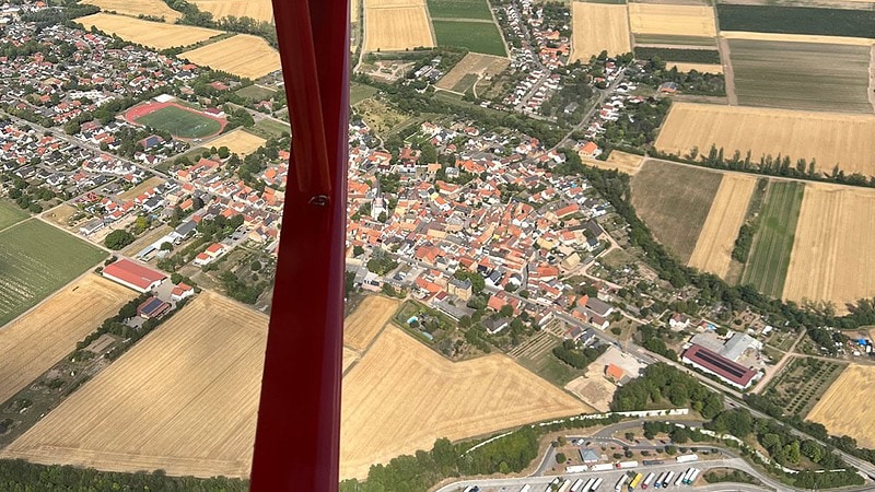 Seitlicher Ausblick auf ein Dorf von einem Flugzeug beim Rundflug ab Mainz