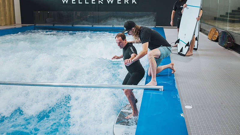 Surfen bei Berlin - Becken mit Wellen und Surfer an der Seite mit Surflehrer