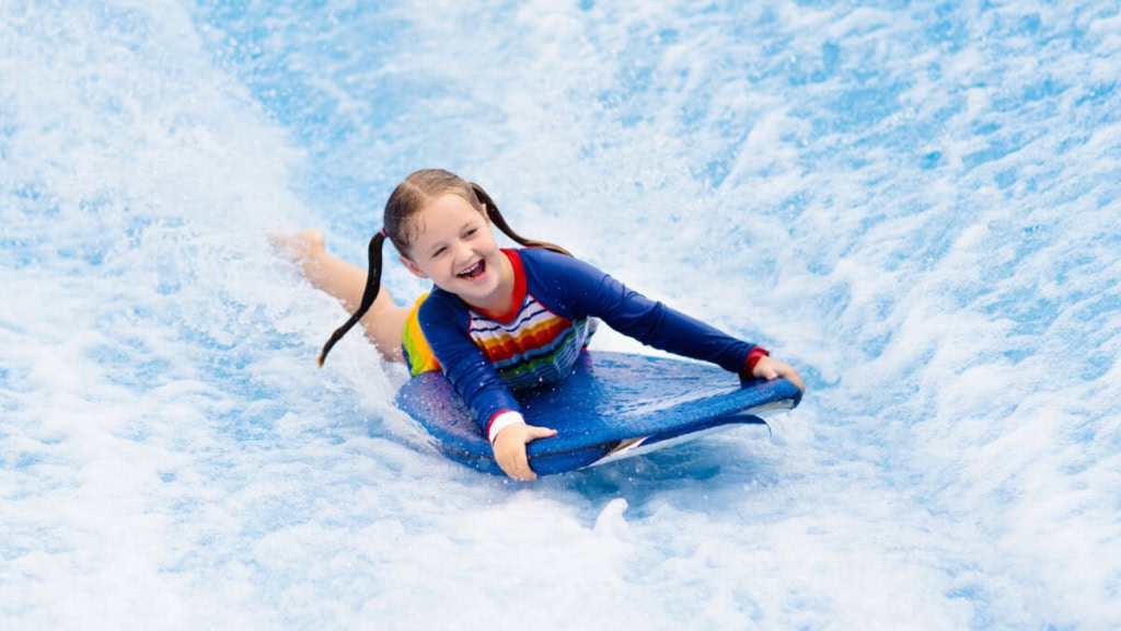 surfkurs-indoor (1) Ein Mädchen lernt wie man surft bei einem Indoor Surfkurs