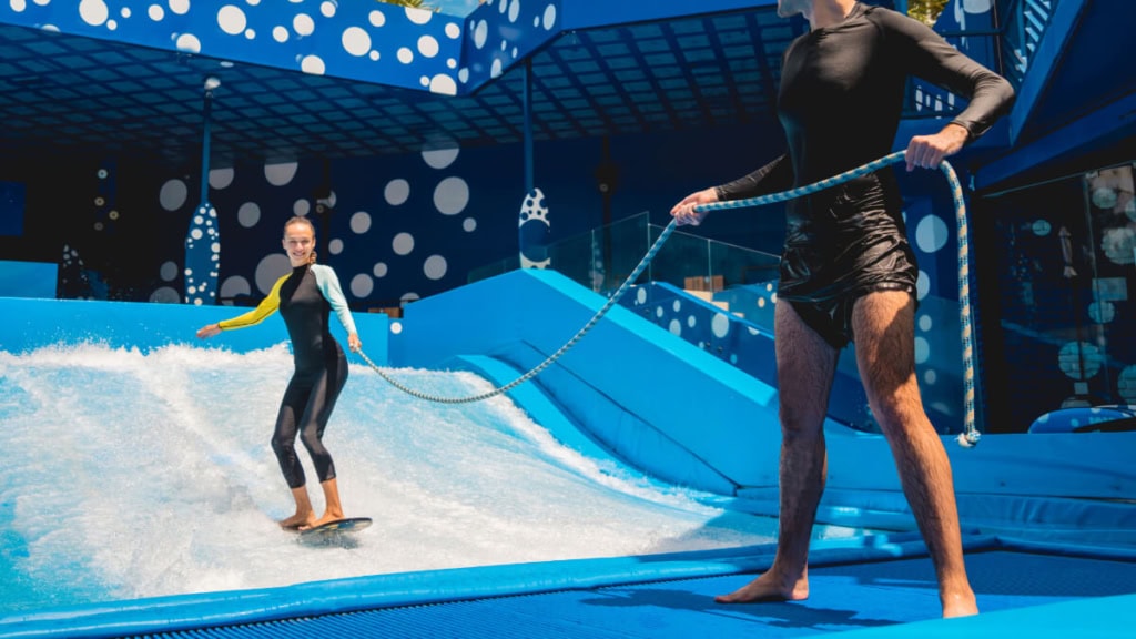 surfkurs-indoor (2) Eine Frau lernt wie man surft bei einem Indoor Surfkurs
