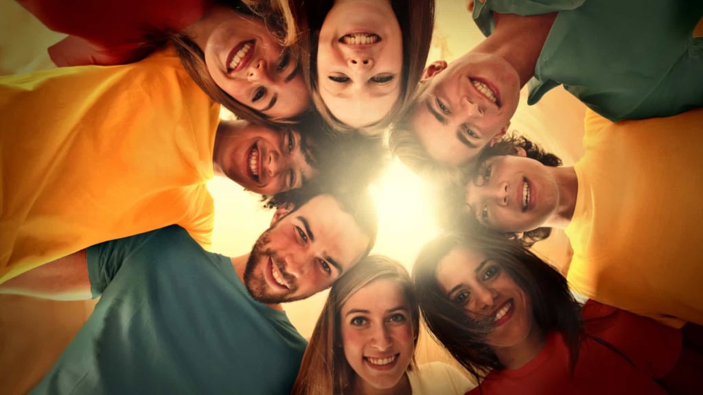 sonstige-anlass-people-happy Verschiedene Menschen schauen nach unten in die Kamera, die Sonne scheint hindurch