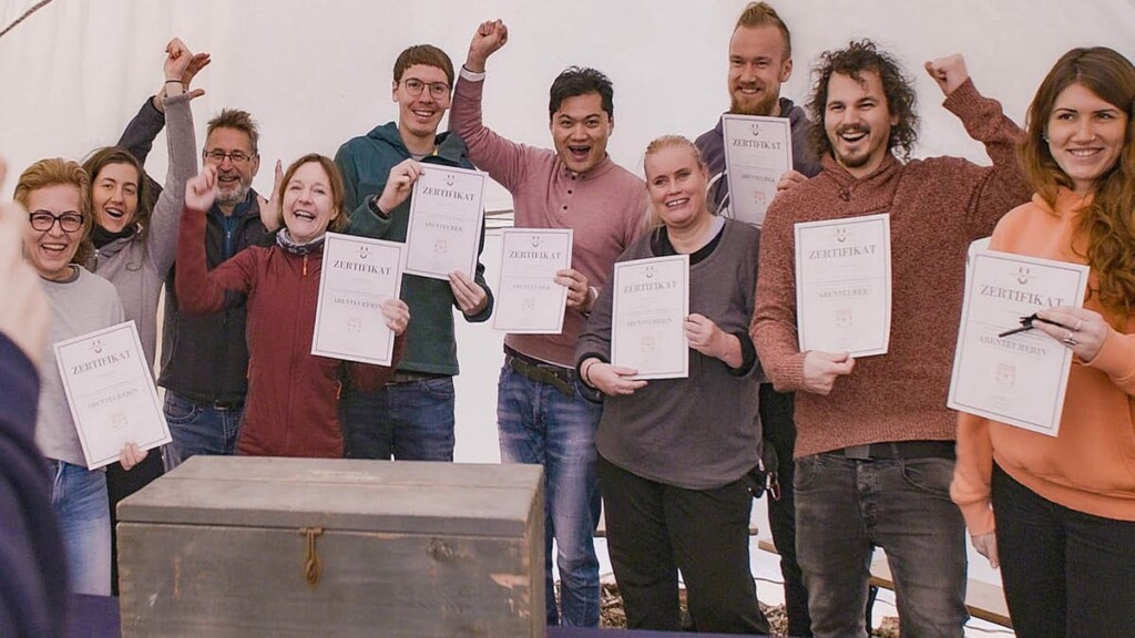 Abenteuer-Gameshow-Adventure-in-Berlin17.jpg 10 Menschen haben ein Zertifikat in der Hand und jubeln in die Kamera