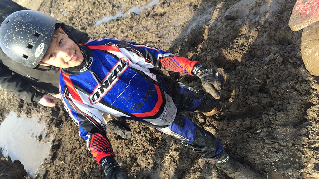 Kinder Quad Leipzig- Kind Ein Kind ist bei einer Quad Tour schlammbedeckt.