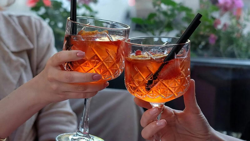 2 Personen stoßen mit Aperol Spritz an