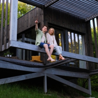 besondere-uebernachtungen Ein Paar sitzt zusammen auf einer Terrasse eines Tiny Houses, wo sie übernachten werden