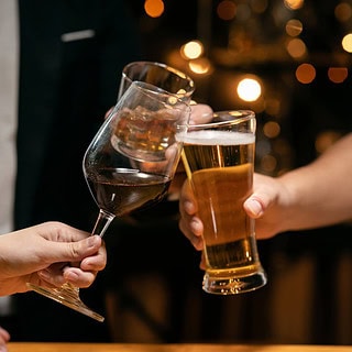 bier-wein-genuss (1) das Foto zeigt 3 Gläser, mit denen man anstößt - ein Weinglas, einen Bierkrug und ein Glas mit einem Drink
