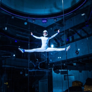 Eine Frau fliegt in einem dunklen Windkanal