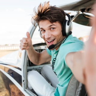 ein Mann versucht sich zum ersten Mal als Pilot und macht ein Selfie mit Daumen hoch