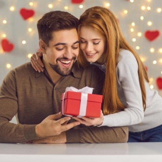 Ein Paar verbringt zusammen den Valentinstag, der Mann kriegt ein Geschenk von seiner Frau