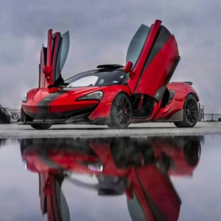 geschenke-fuer-ps-fan ein roter McLaren mit nach oben geöffneter Tür, in einer regnerischen Umgebung